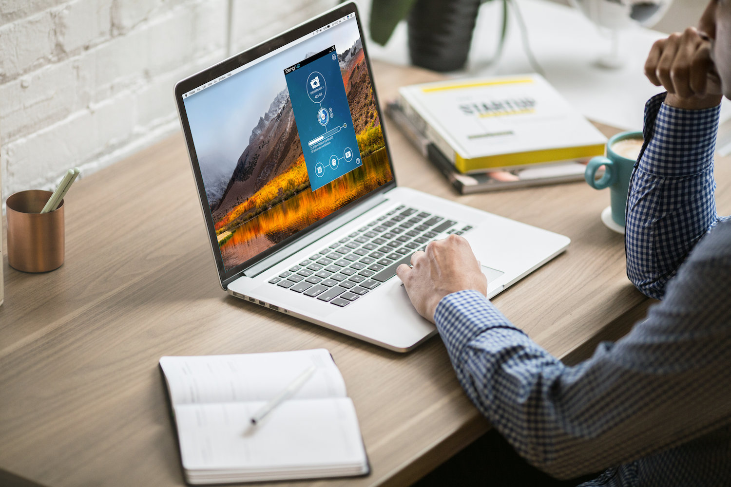 Ein Mann, welcher ein Backup mit Sengi Up an seinem Macbook durchführt